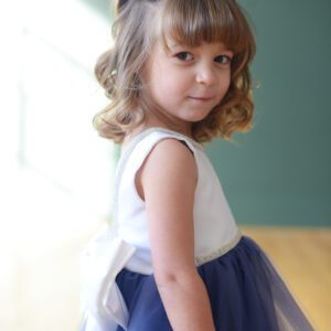 A blue and white flower girl dress with a fulle tulle skirt and diamante trim