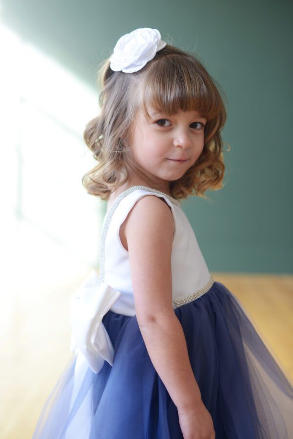 A blue and white flower girl dress with a fulle tulle skirt and diamante trim