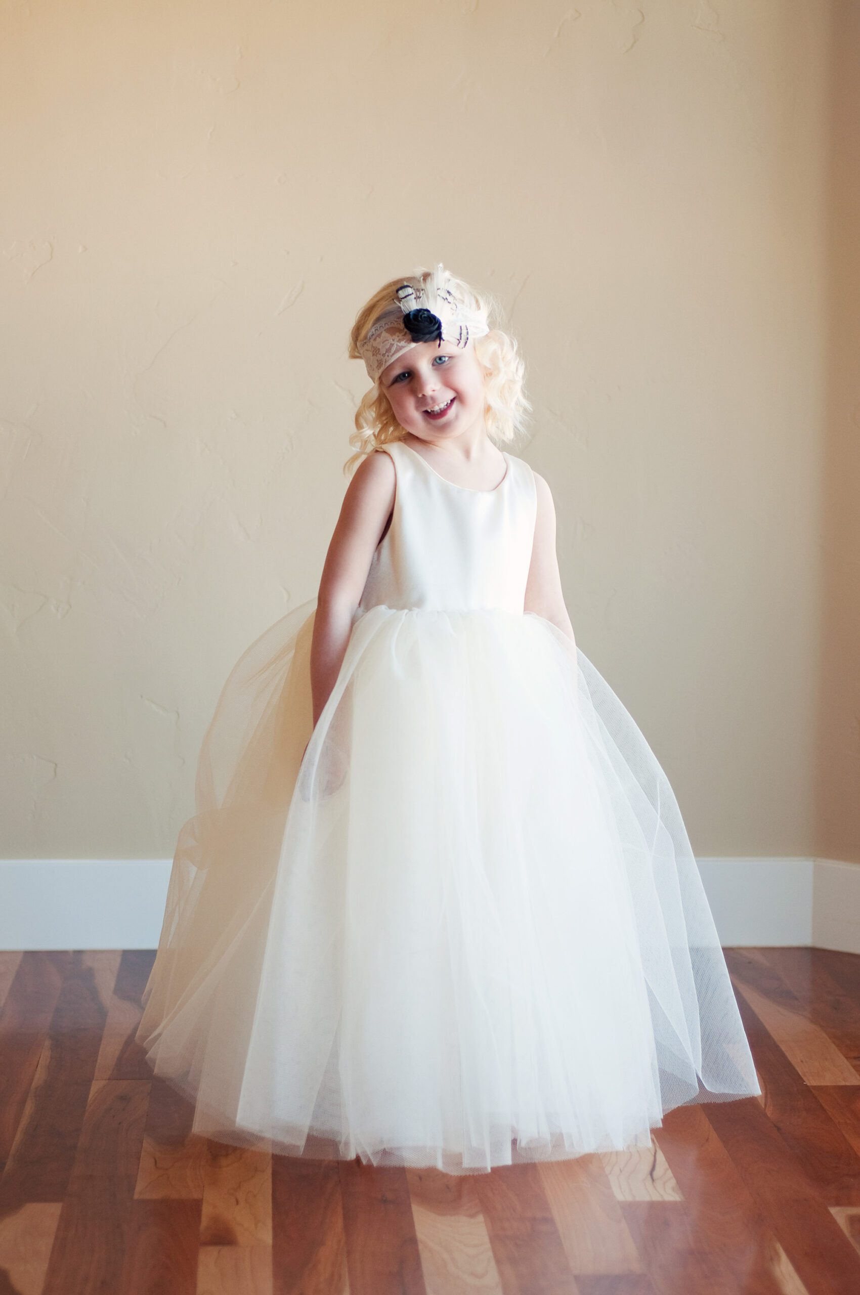 A photo of a flower girl wearing a cotton flower girl dress with a very full tulle skirt