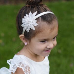 A photo of a flower girl wearing a star Alice band