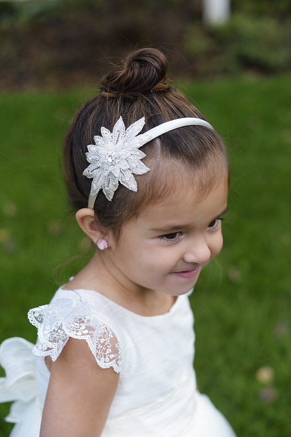 A photo of a flower girl wearing a star Alice band