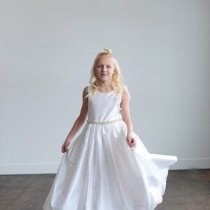 A white silk first communion dress or flower girl dress with a pearl trim