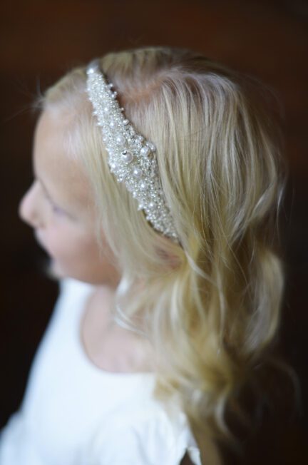 A photo of a child's ivory headband with a pretty diamante motif