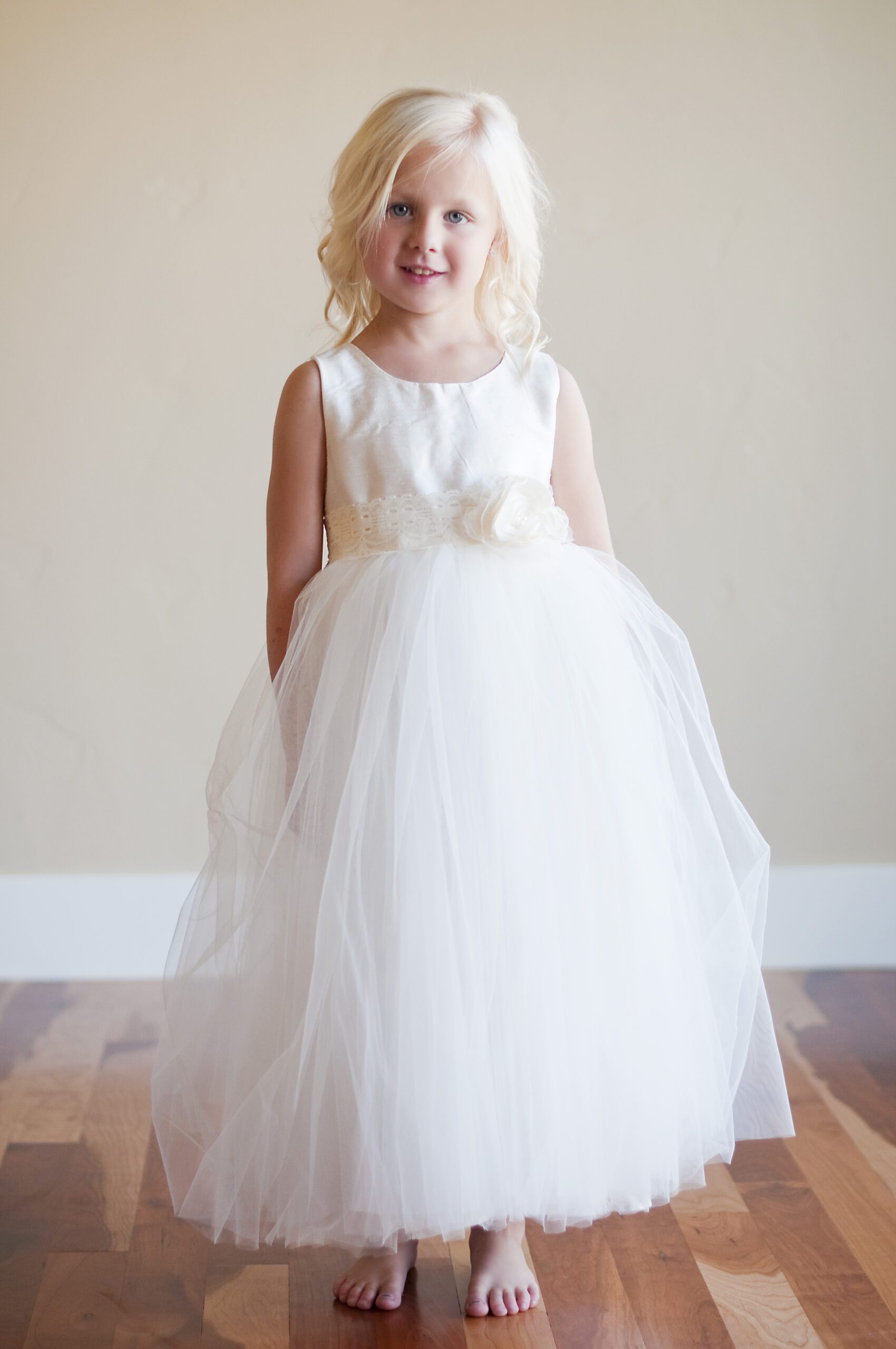 A photo of a flower girl wearing an ivory silk and tulle dress