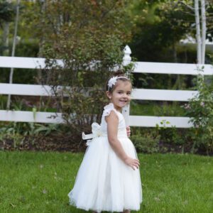 A photo of a girl wearing an ivory lace flower girl dress with full tulle skirt and a star diamante headband