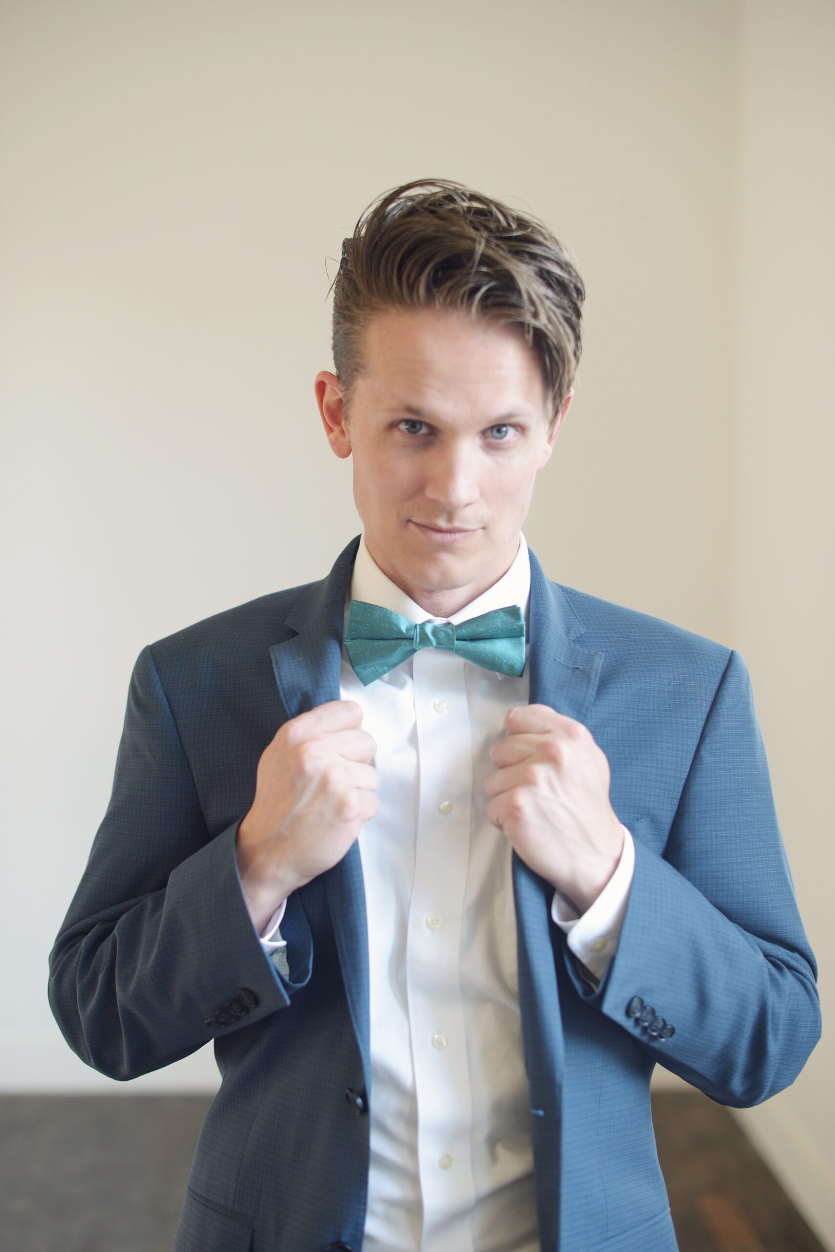 A photo of a man wearing a teal pure silk bow tie