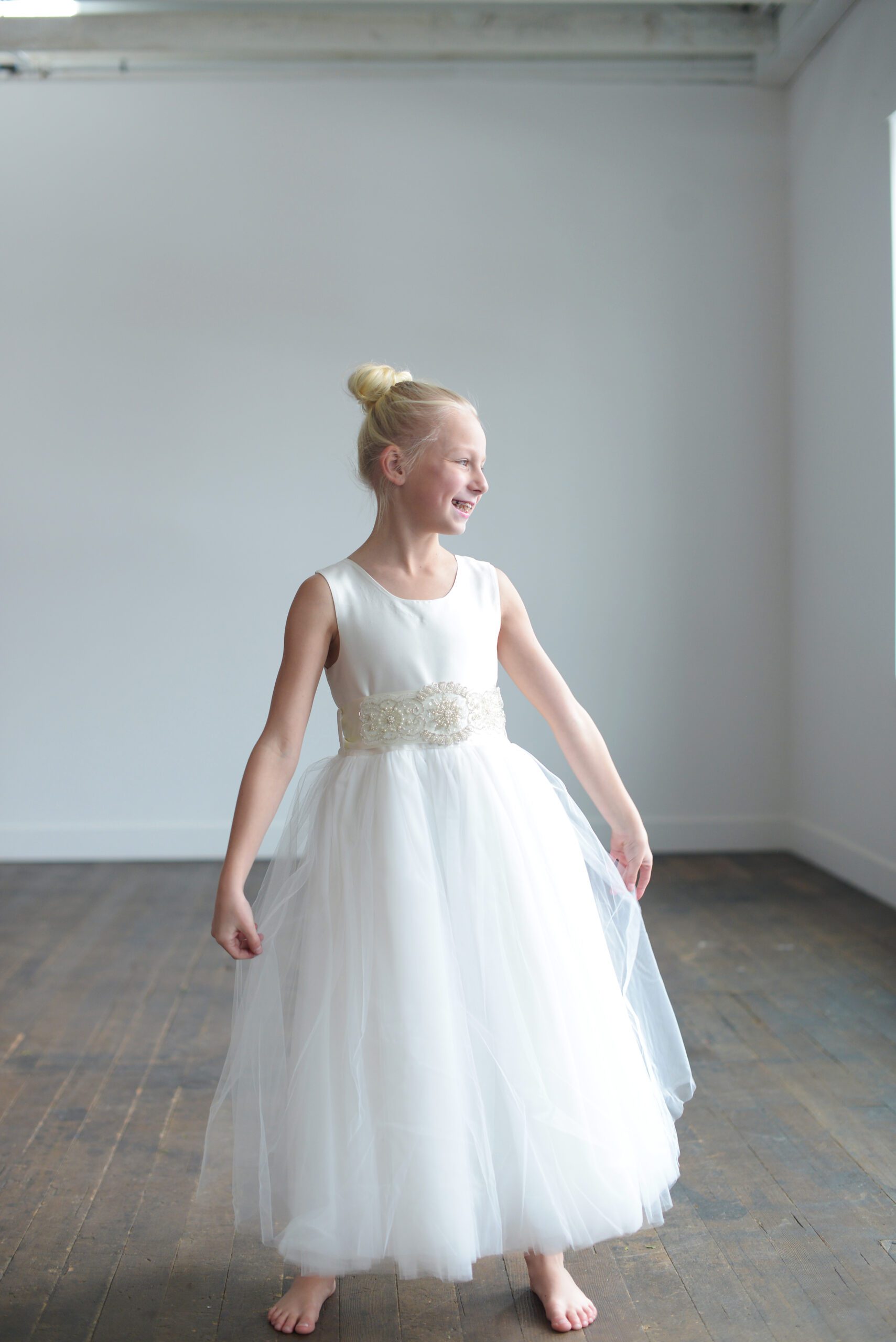 A photo of a flower girl in an ivory tulle and silk dress, handmade to measure. Available in white too.