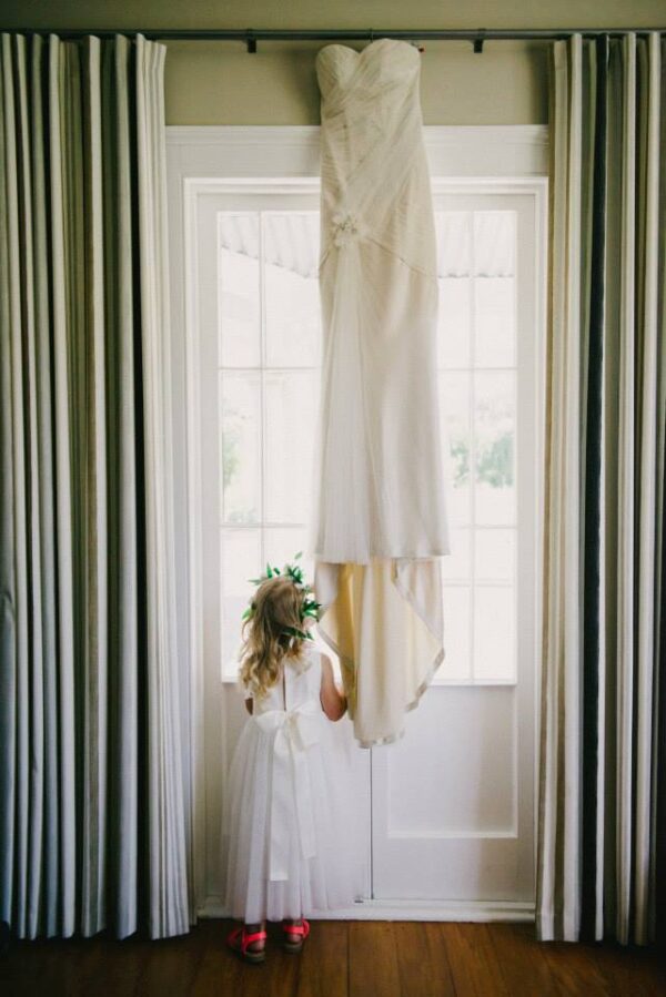A photo of the back of an ivory flower girl dress with a tulle skirt