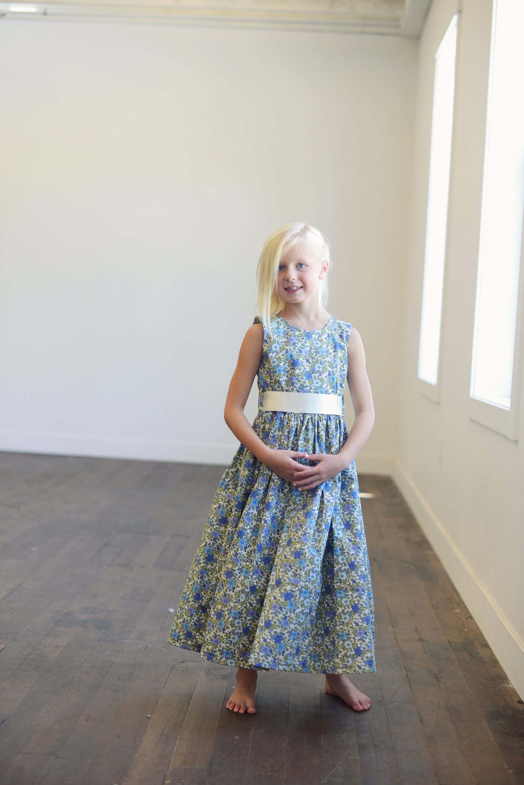 A photo of a blue daisy floral dress in cotton for flower girls