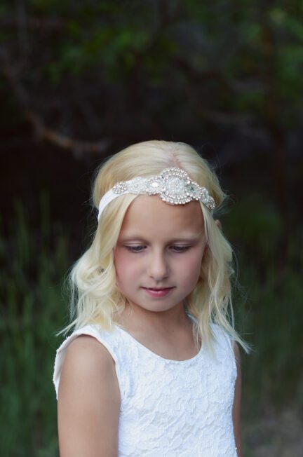 A photo of the Natasha Flower Girl Headband which is an elasticated headband suitable for all head sizes. The headband has a diamante motif and is perfect for flower girls