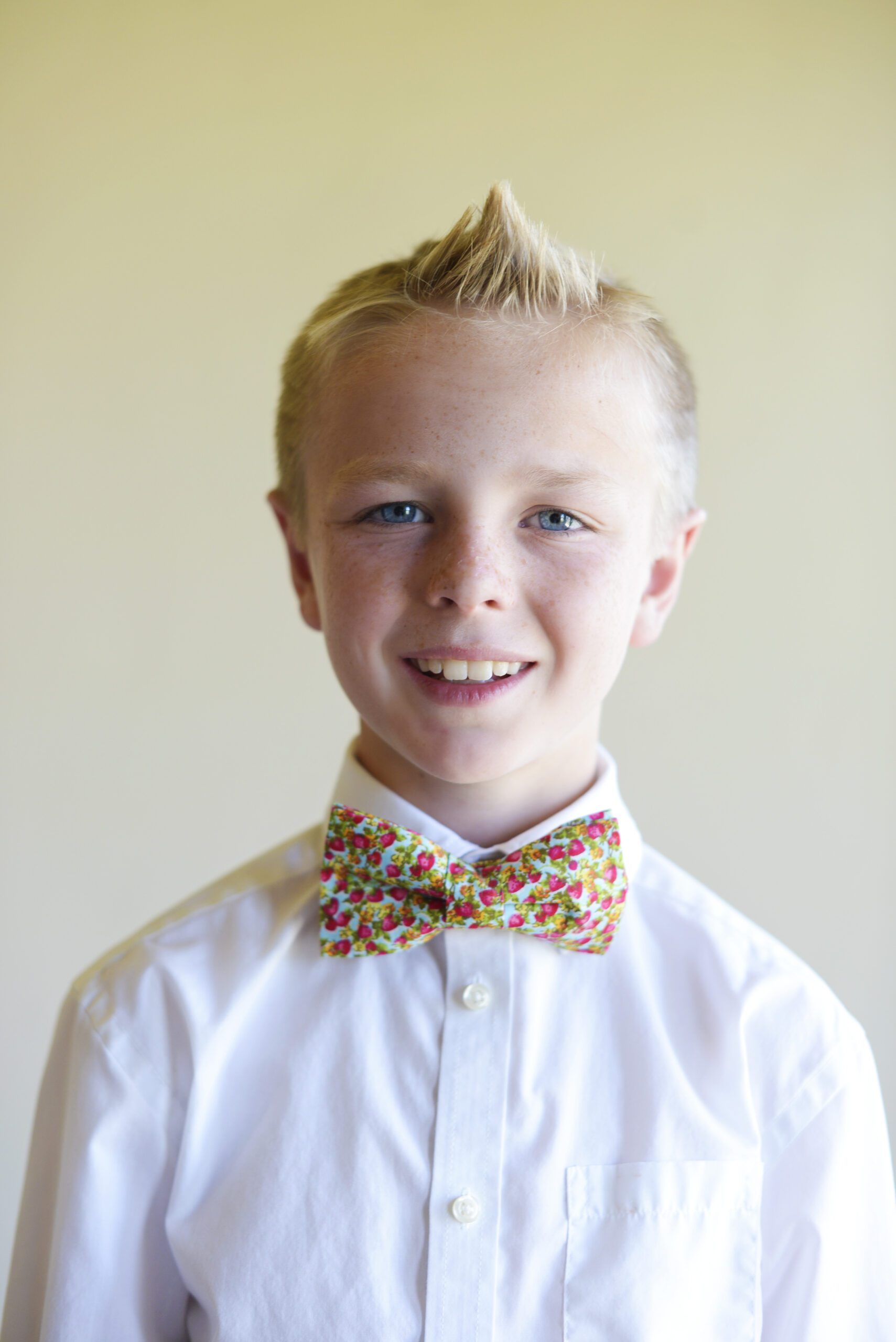 A photo of a boy wearing a floral bow tie