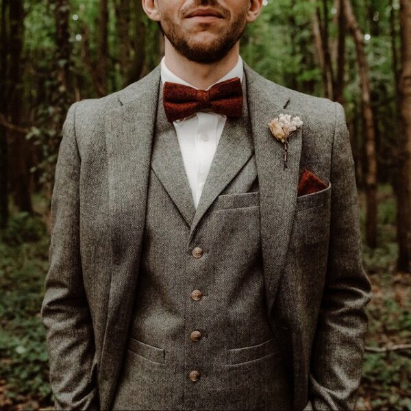 A photo of a man wearing a burnt orange bow tie in flecked wool