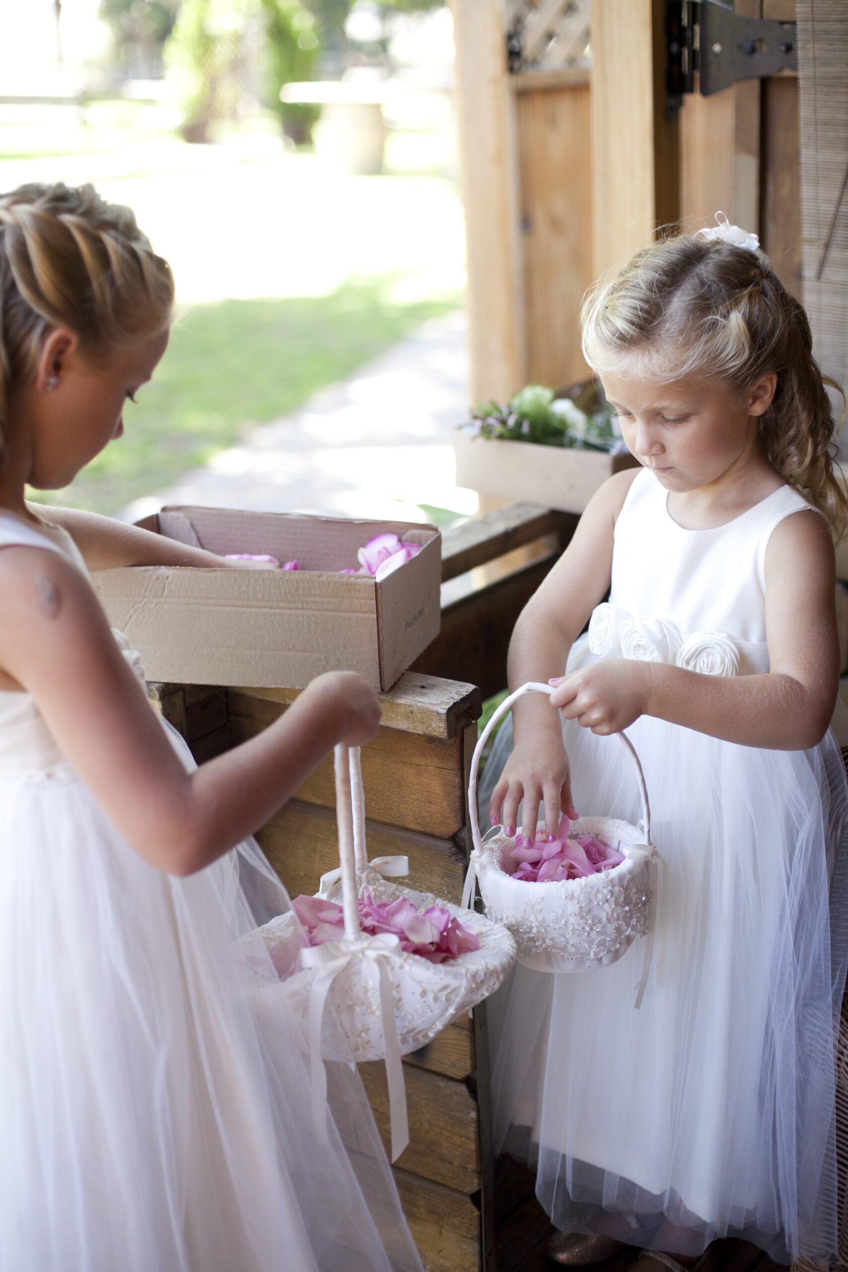An ivory cotton flower girl dress with a tulle skirt and pink silk roses 