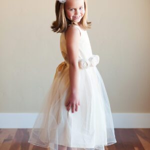 A photo of a ten year old flower girl wearing a cotton dress with roses on the sash