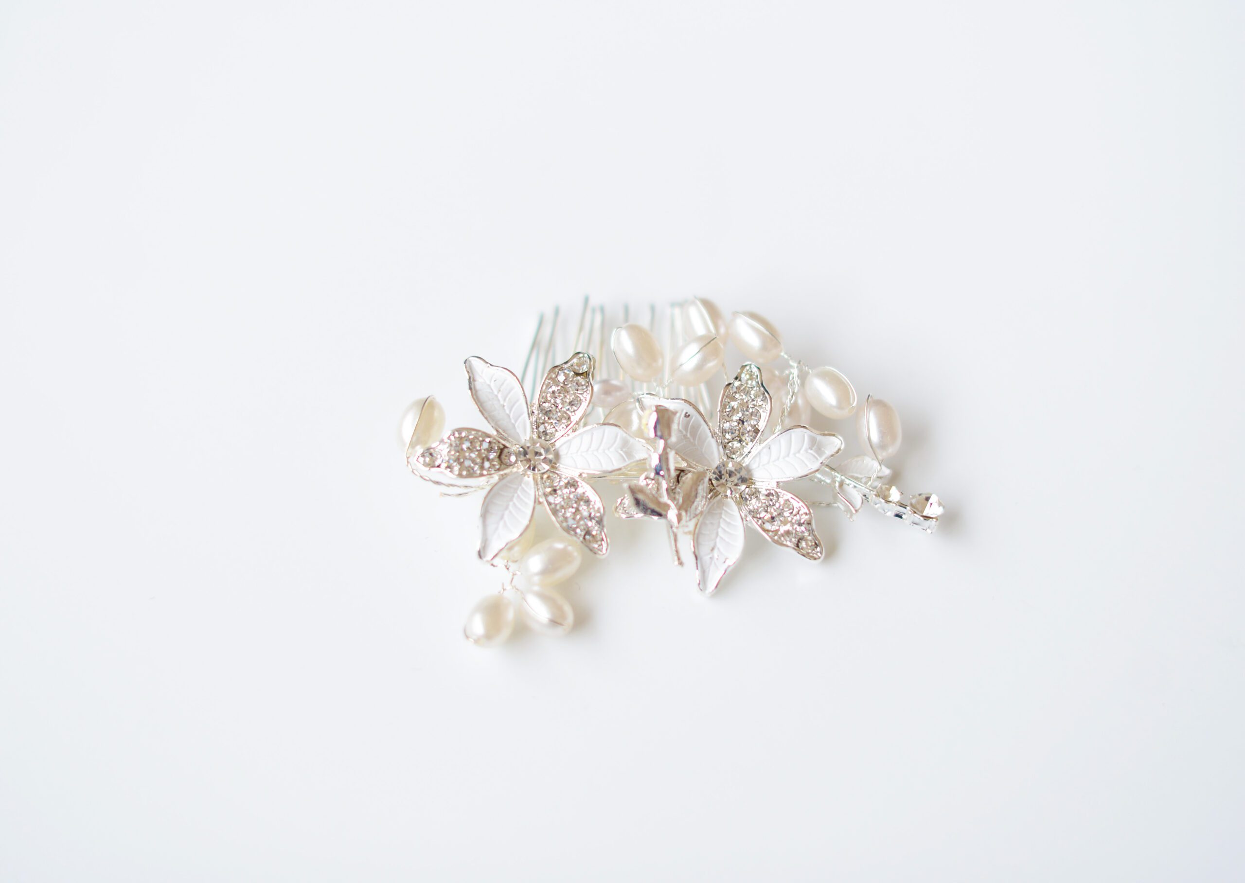 A photo of a silver bridal hair comb with delicate flowers