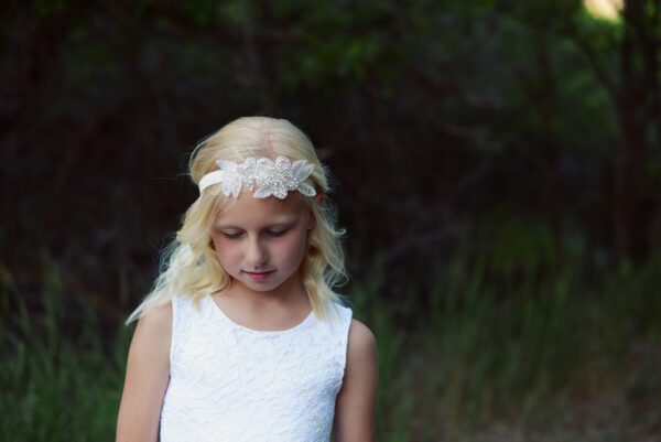 A photo of an elasticated headband for all sizes and comes in ivory and white.