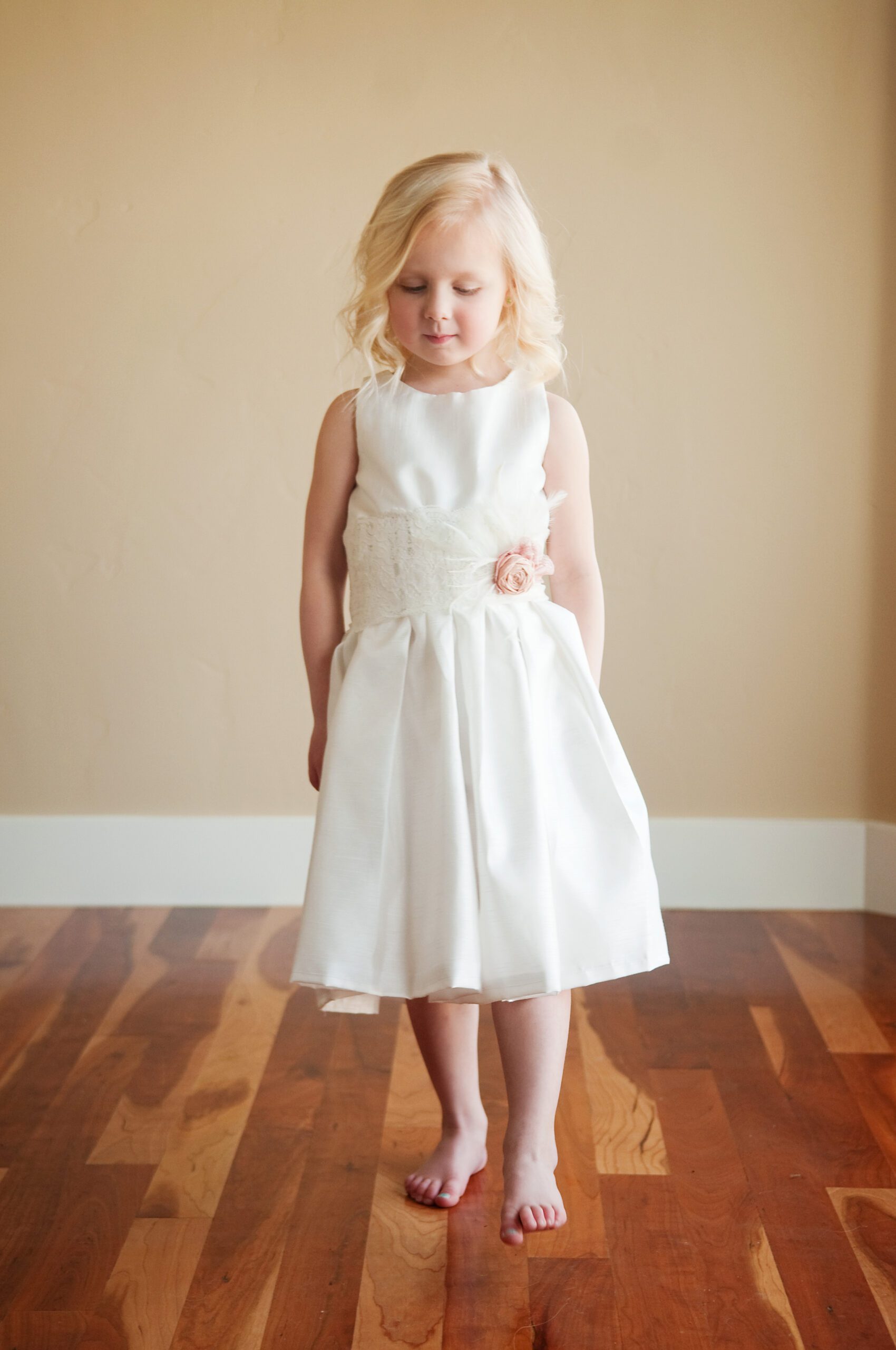 A photo of a 4 year old girl wearing an ivory cotton hand made flower girl dress