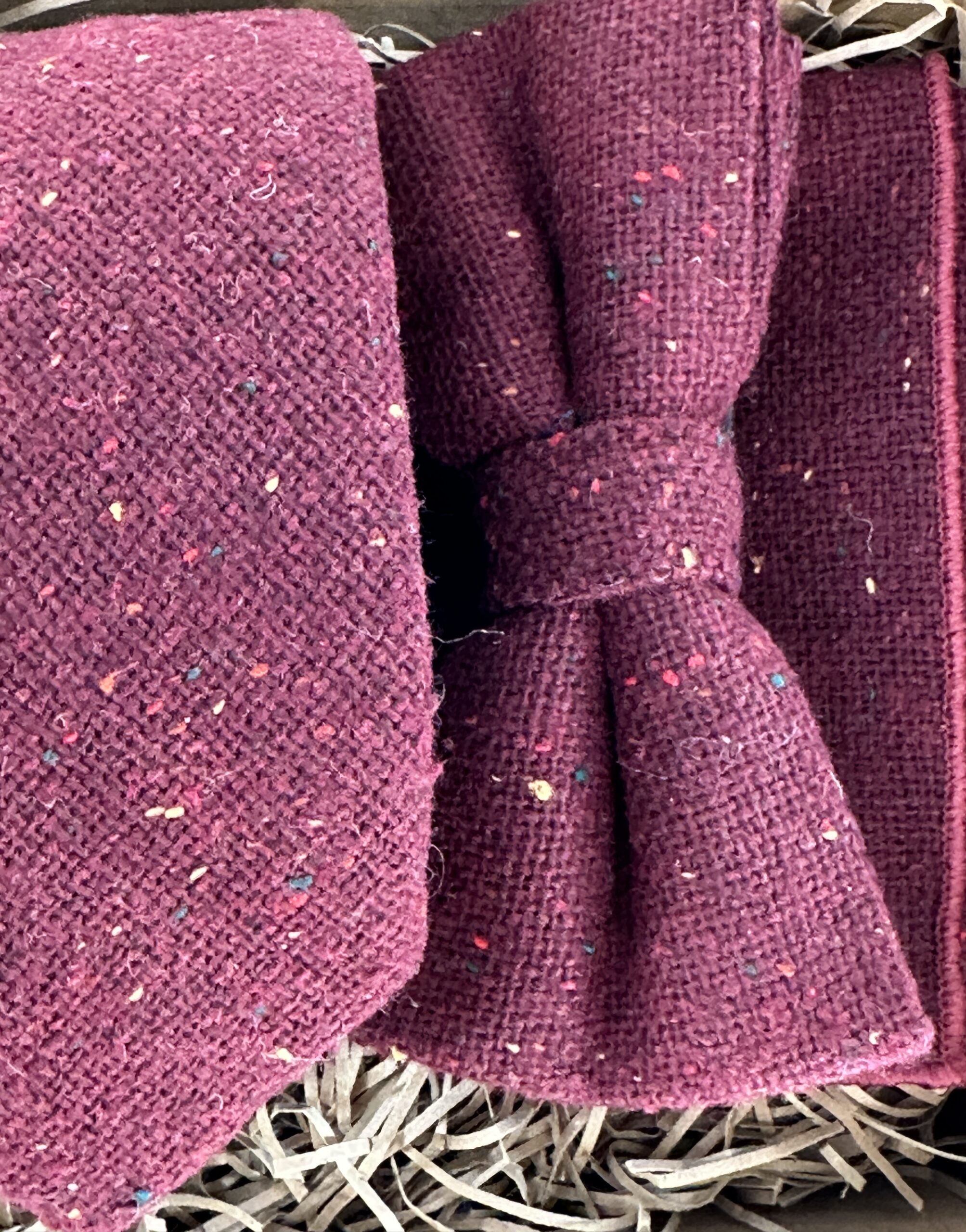 A photo of a burgundy flecked wool tie, bow tie and pocket square set ideal as groomsmen gifts and mens gifts