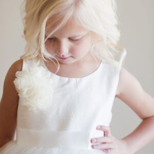 A photo of a peony flower girl dress in ivory with a full tulle skirt and silk bodice