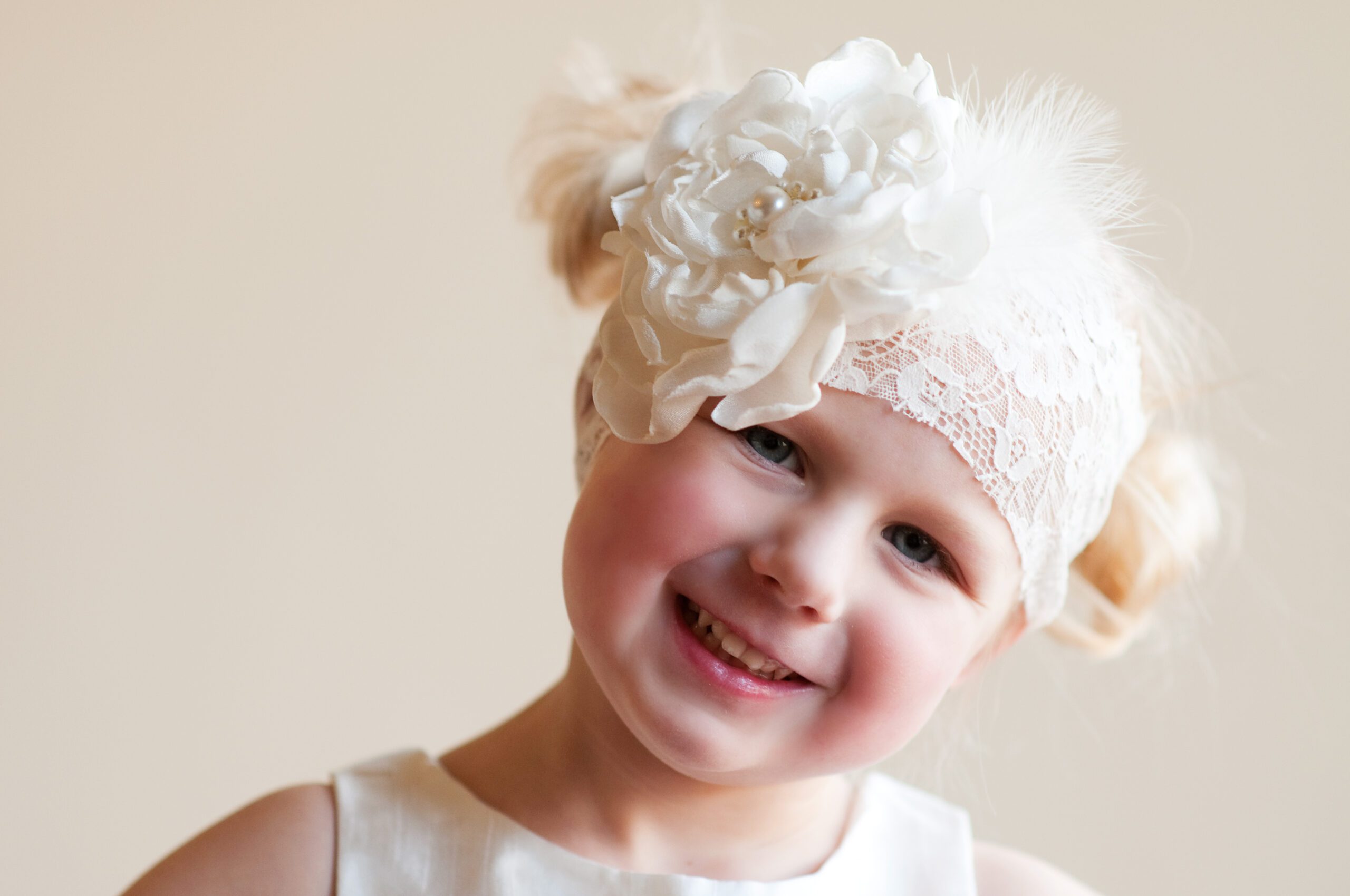 A photo of a lace flower girl headband with an oversized flower in ivory