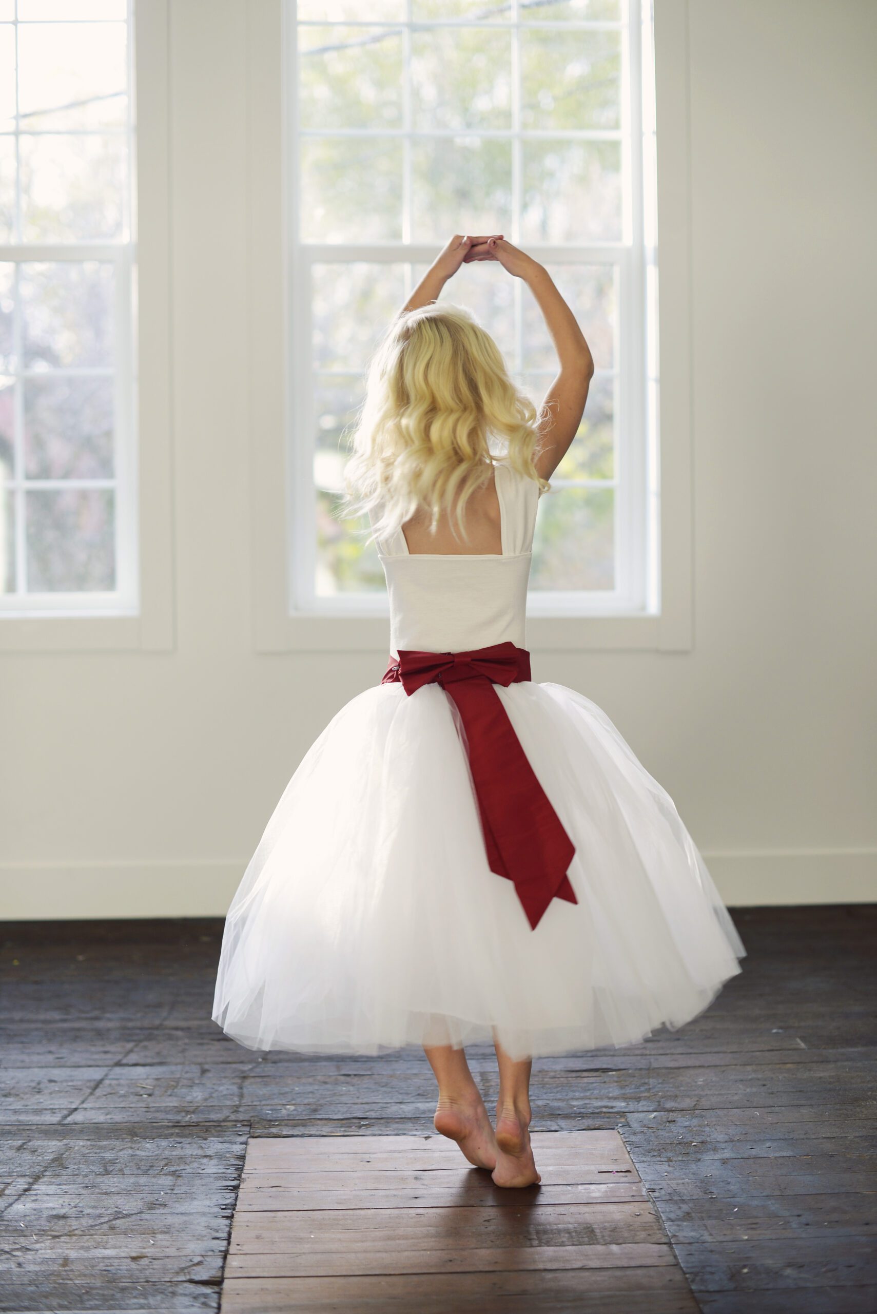 A photo of a flower girl in a red and white tutu skirt