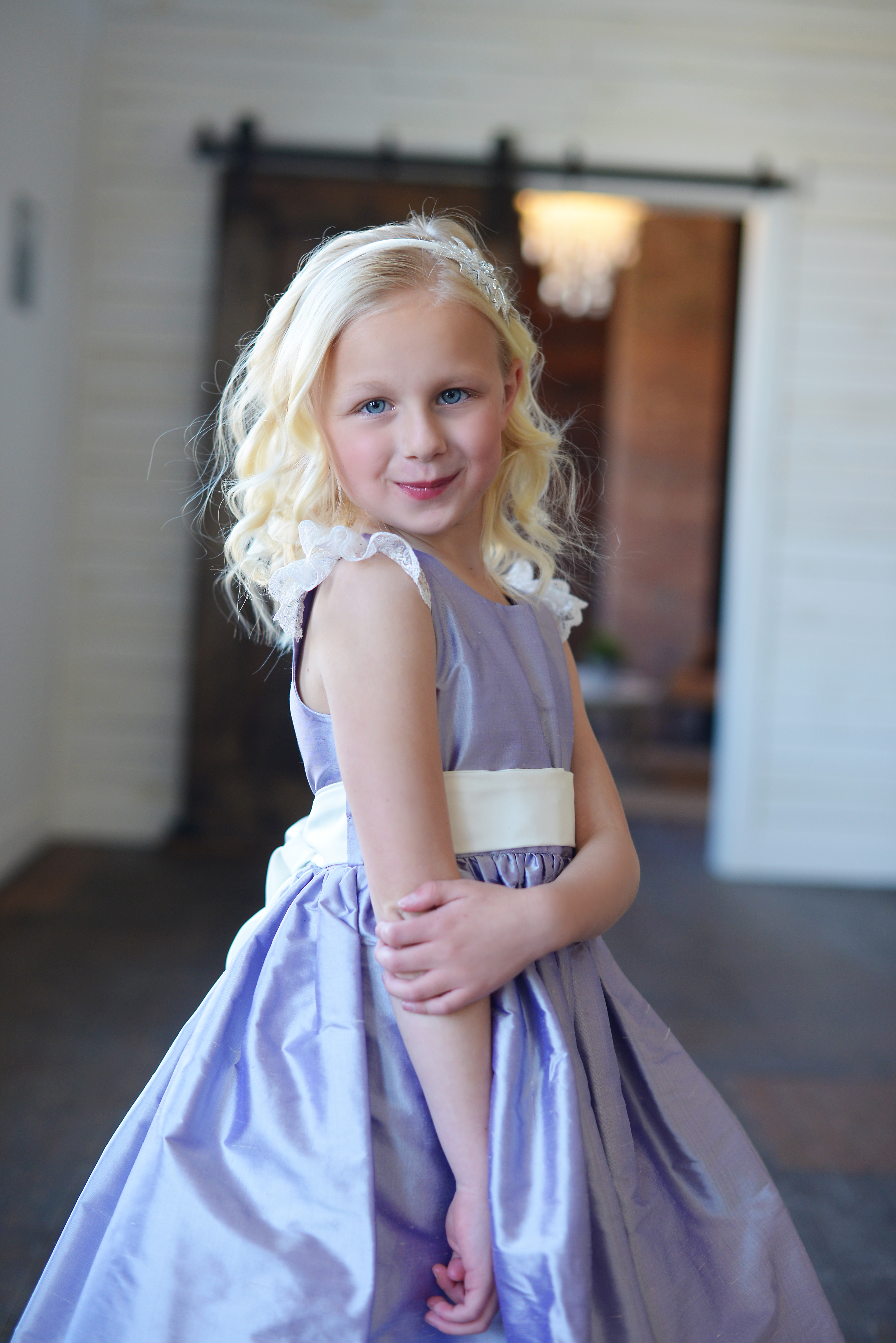 A photo of a purple silk flower girl dress with an ivory belt which is made to measure