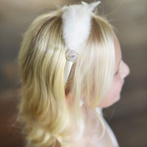 An ivory or white satin headband with diamante and feathers.