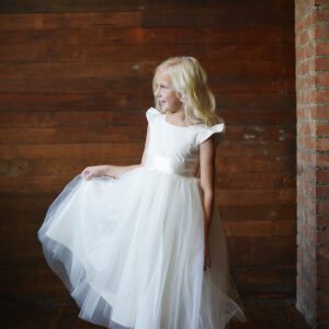 A cotton ivory or white flower girl and first communion dress wit a tulle skirt.