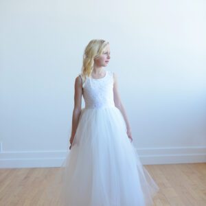 An ivory and white lace flower girl dress with a full tulle skirt