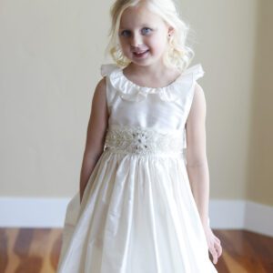 A photo of an ivory silk flower girl dress with a v back and ruffle collar