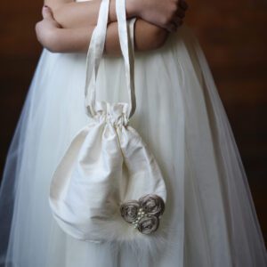 A photo of a silk flower girl or first communion bag
