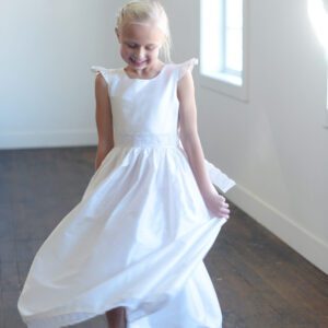 A photo of a pure silk white first communion dress with a lace belt