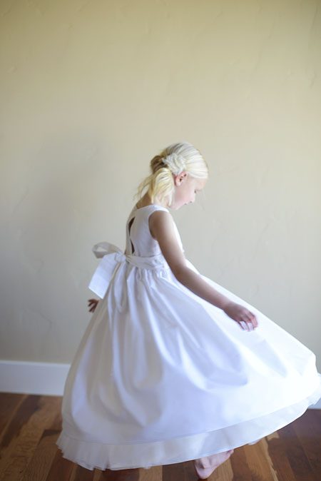 A photo of the back of the simple cotton flower girl dress in white or ivory cotton