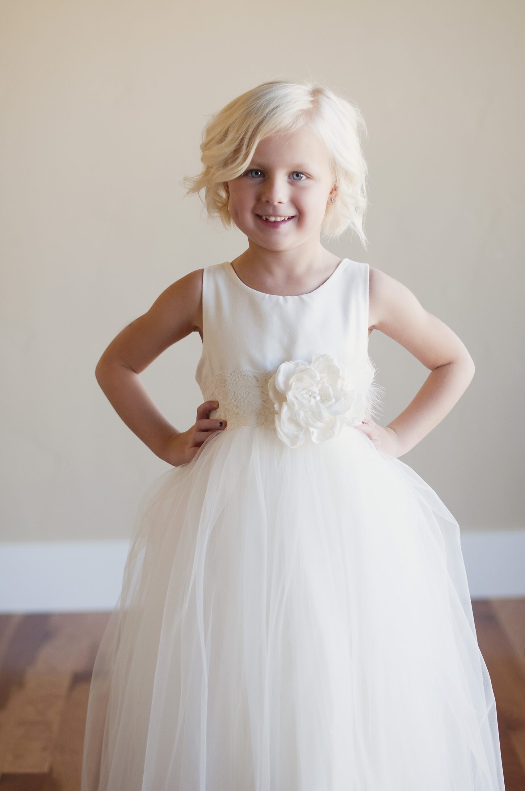 A photo of a 5 year old girl wearing an ivory flower girl dress with a tulle skirt for twirling