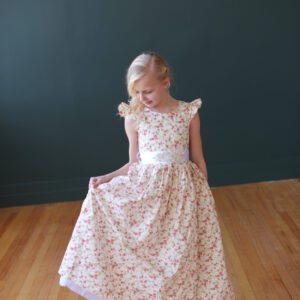 A photo of a 10 year old girl wearing a floral flower girl dress with capped sleeves