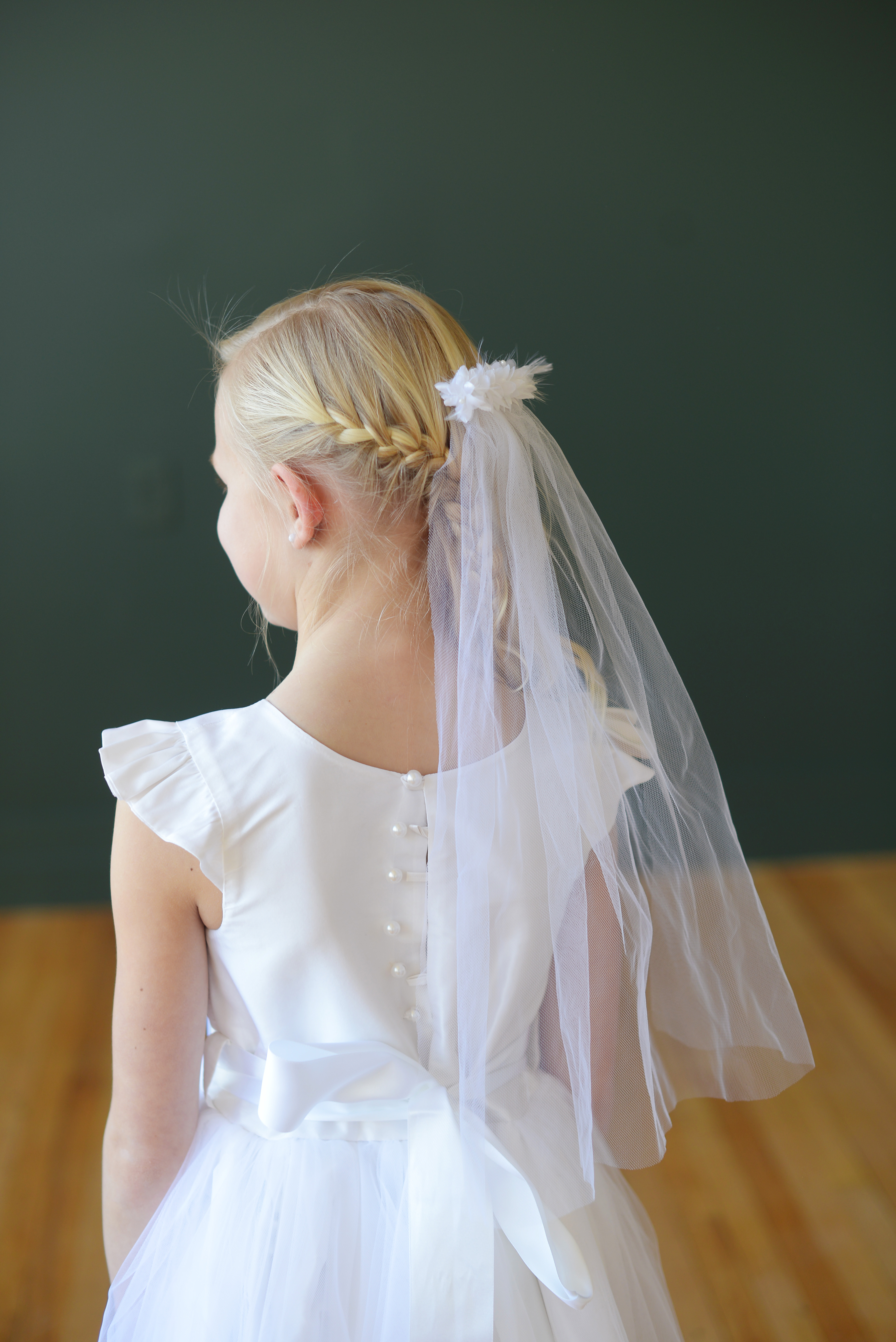 A photo of a white silk flower girl dress with a full tulle skirt