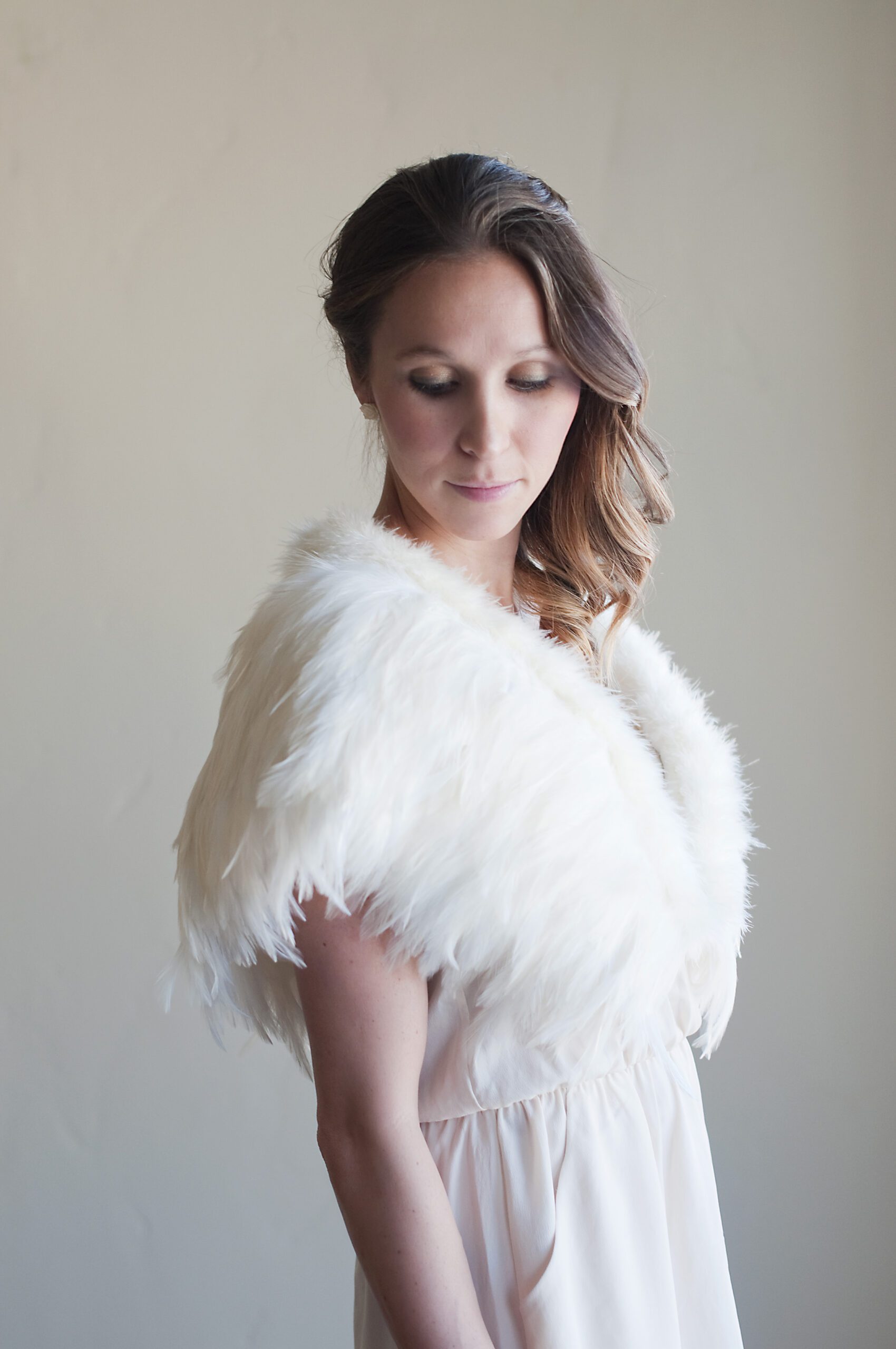 A photo of a feathered wedding shawl in ivory or white