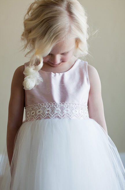 A photo of a silk flower girl dress with a full tulle skirt