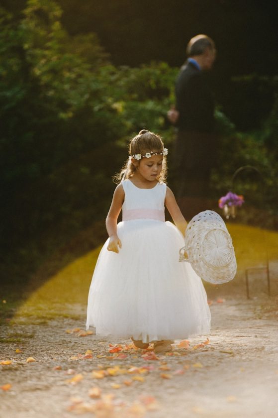 A photo of a 4 year old flower girl wearing a silk and tulle dress in ivory with a blush pink sash