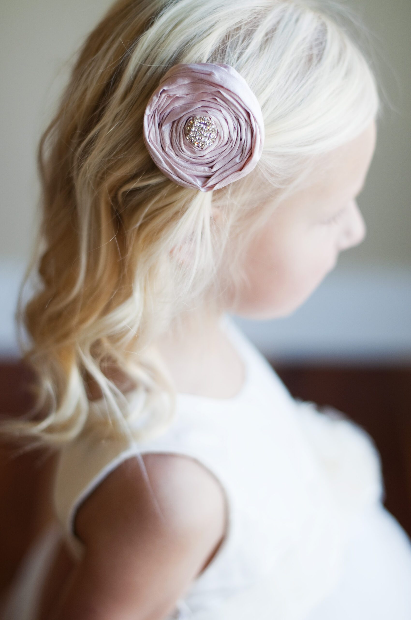 A photo of a blush pink silk rose for flower girls. The rose is available in a wide range of colours.