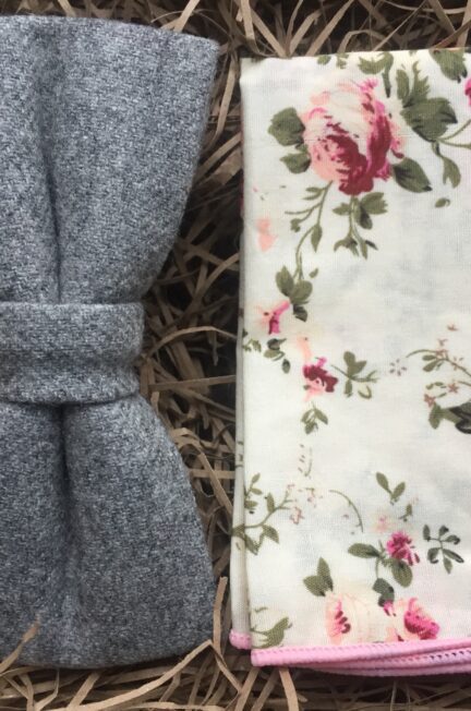 A photo of a grey wool bow tie and a pink floral pocket square