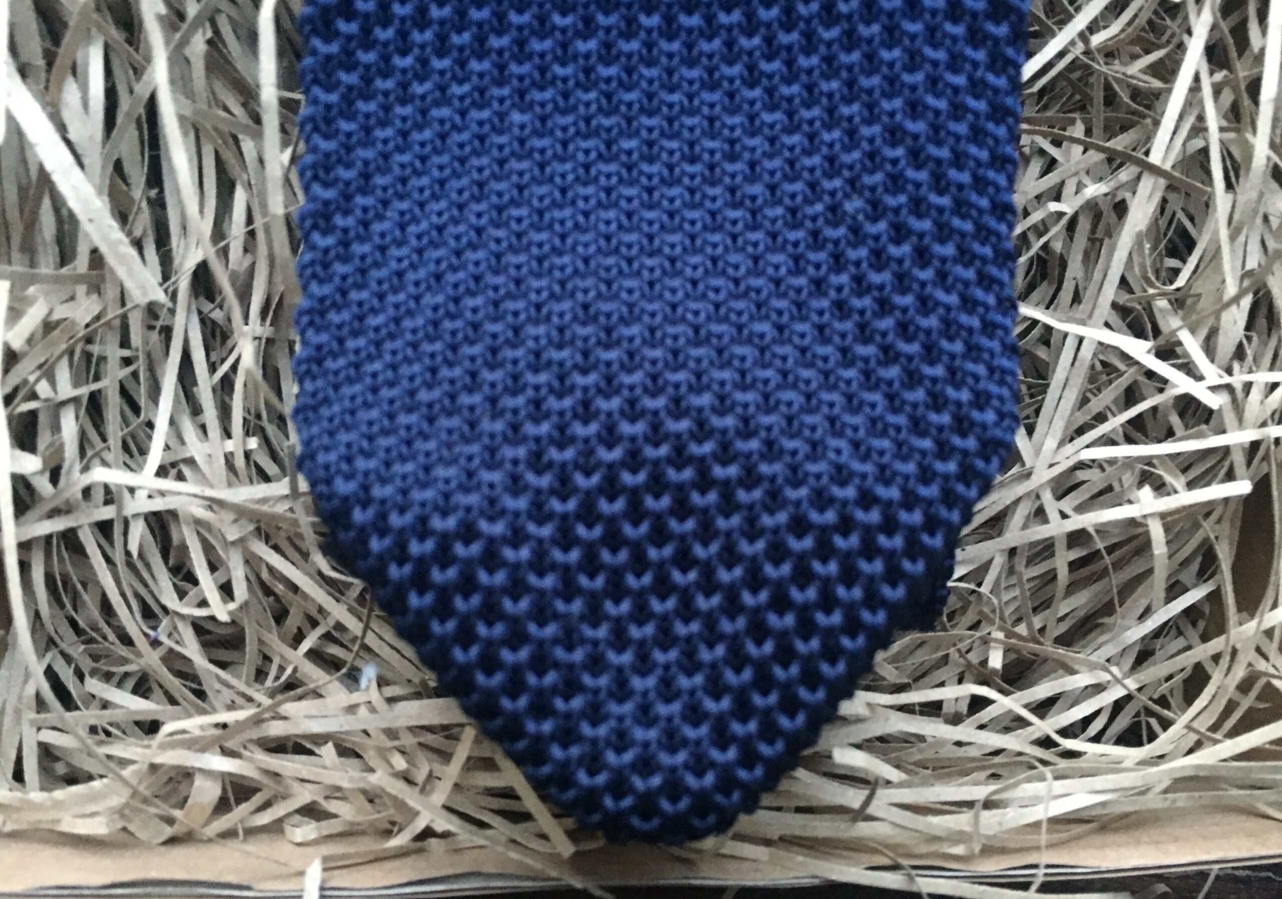 A photo of a navy blue knitted mens tie