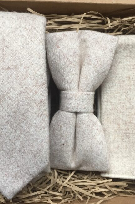 A photo of a cream wool tie, bow tie and pocket square perfect as a groomsman gift or men's gift