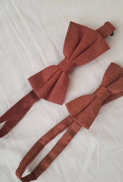 A photo of of an adult and child burnt orange bow tie.