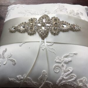 A photo of a beaded lace ring pillow in ivory with a diamante motif