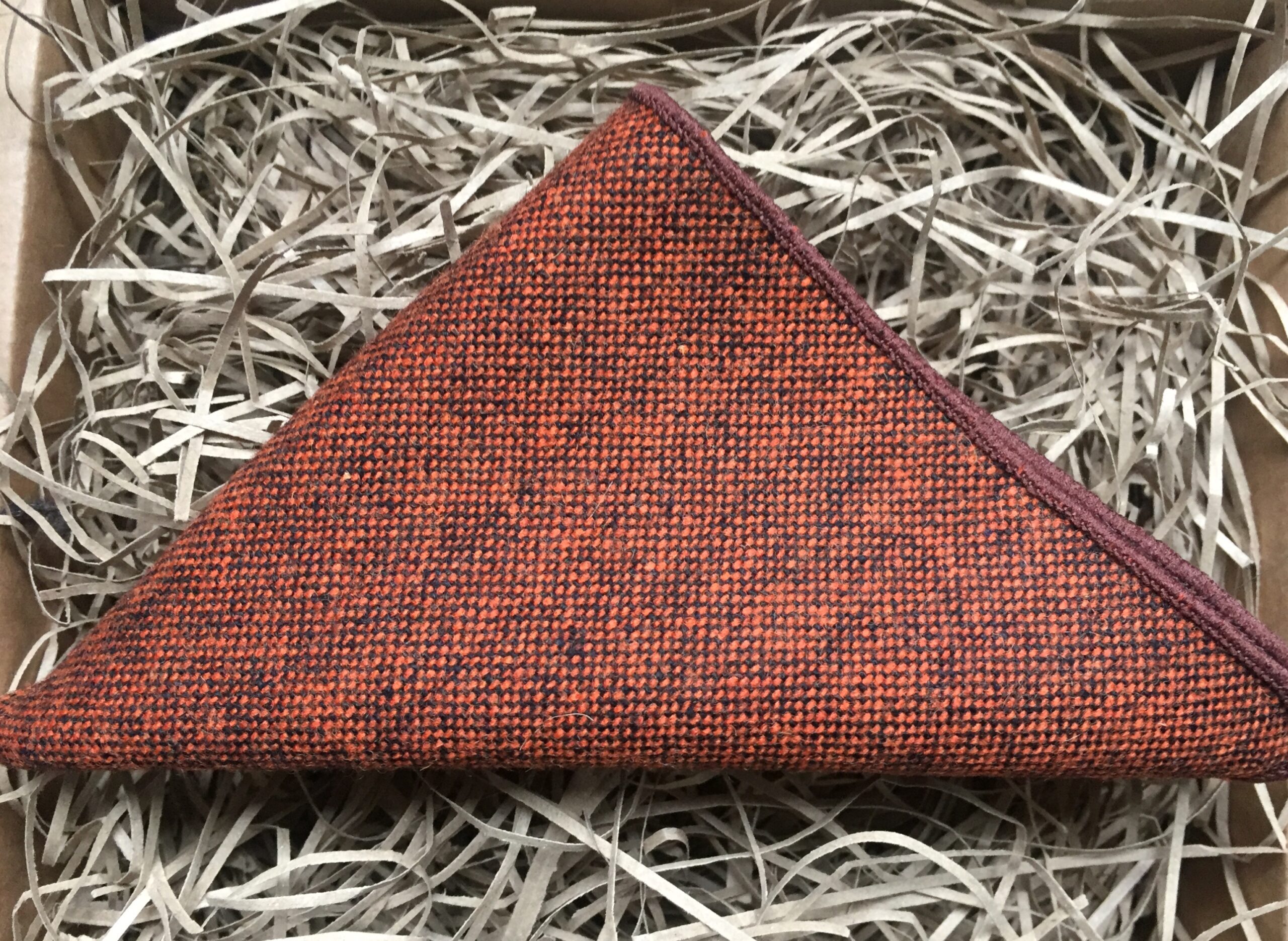 A photo of a burnt orange wool pocket square for men and women