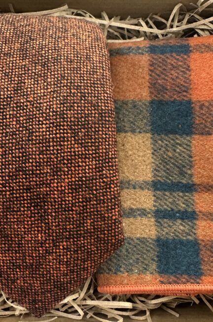 A photo of a burnt orange tie and checked pocket square