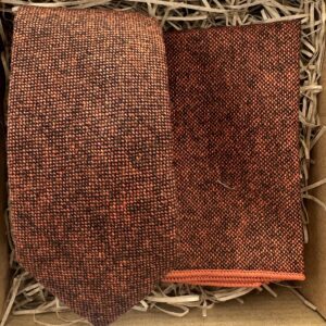 A photo of a burnt orange wool men's tie and pocket square