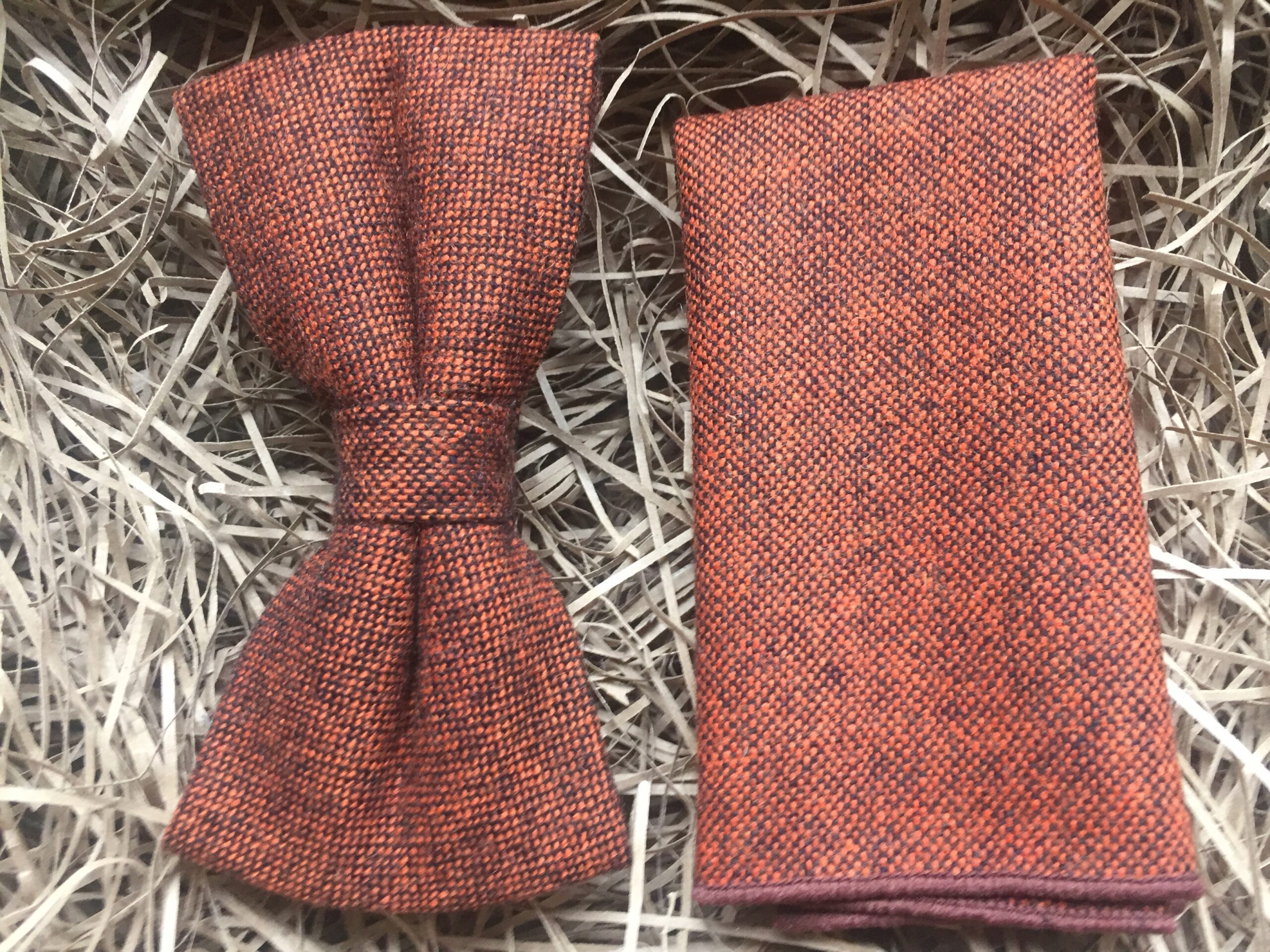 A photo of a men's wool, burnt orange bow tie and pocket square in free gift wrapping