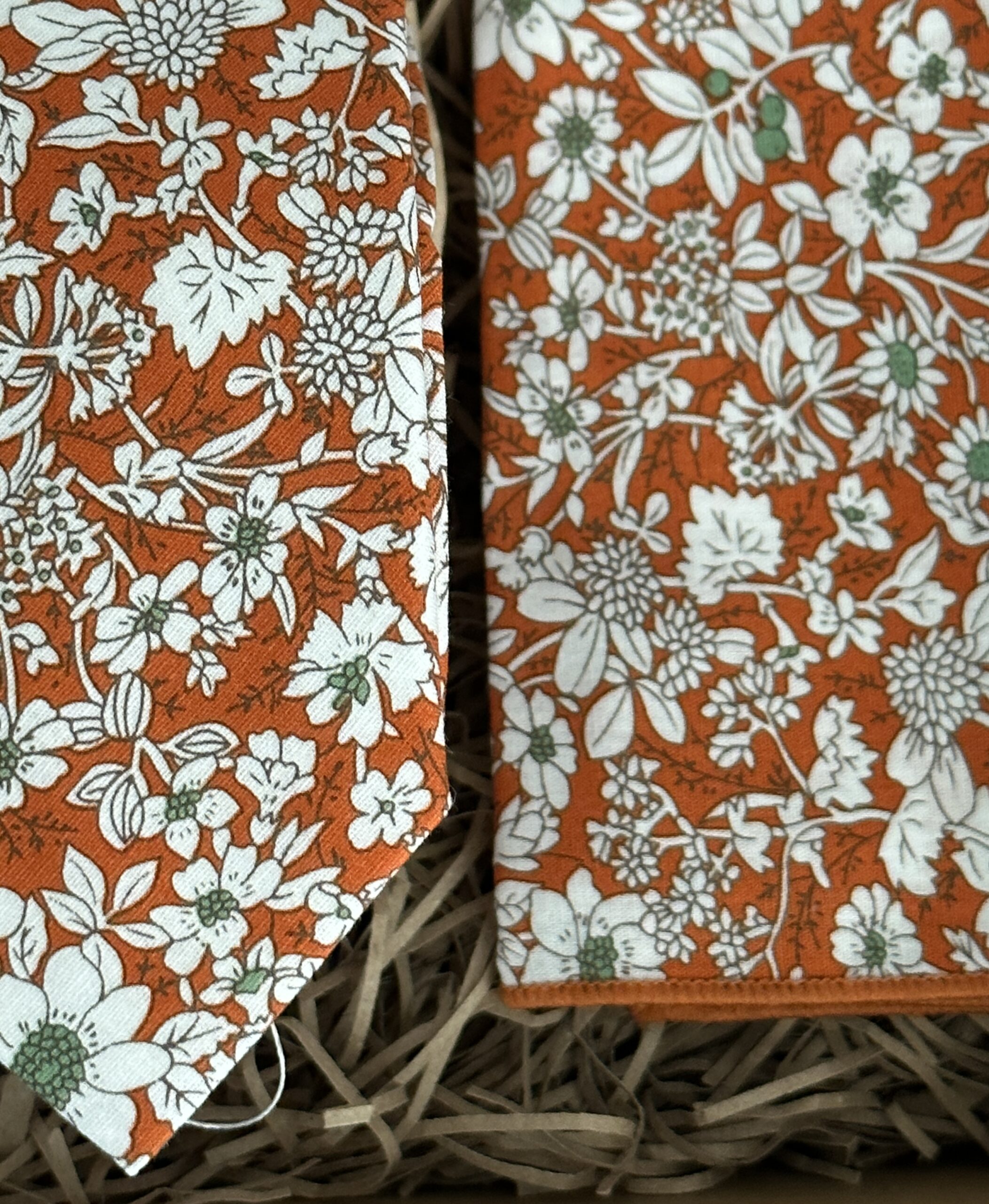 A photo of an orange floral tie and pocket square in cotton